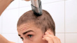 young man doing his own buzzed haircut with a clipper | BahVideo.com