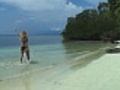 Woman walking on the lagoon along a desert tropical island | BahVideo.com
