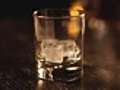 Whiskey glass filled with ice and drink close-up | BahVideo.com