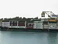 Royalty Free Stock Video HD Footage Tug Boat Passes by a Container Cargo Ship at the Port of Honolulu Hawaii | BahVideo.com