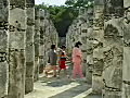 Royalty Free Stock Video SD Footage Zoom Into Columns of Mayan Temple as Tourists Pass by at Chichen Itza in Mexico | BahVideo.com