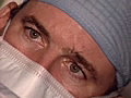 Royalty Free Stock Video SD Footage Zoom Out From Tight Shot of Surgeons Face and Laparoscopic Equipment in Hospital Operating Room as Surgeon Intently Watches Monitor | BahVideo.com