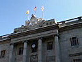 Royalty Free Stock Video HD Footage Pan to Top of Police Office Building and Flags in Barcelona Spain | BahVideo.com