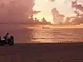 Royalty Free Stock Video HD Footage Static Shot of Ft Lauderdale Beach at Sunrise With Ship on Horizon as Runabout Leaves Area | BahVideo.com