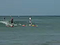 Royalty Free Stock Video HD Footage Three Surfers Ride a Wave at Waikiki Beach in Honolulu Hawaii | BahVideo.com